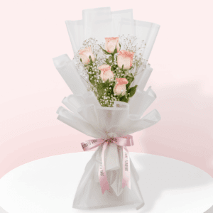 A small bouquet of 5 stem light pink rose, with greenery, wrapped in white, and tied with a baby pink ribbon.