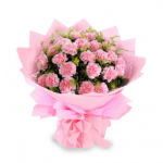 A bouquet of light pink carnations with green fillers, wrapped in soft pink tissue and tied with a matching bow.